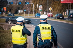 Zdjęcie przedstawiające policjantów ruchu drogowego w trakcie pomiaru prędkości.