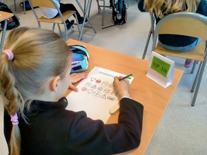 Zdjęcie przedstawiające dziewczynkę w trakcie pisania testu.