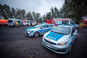 Zdjęcie przedstawiające służby medyczne: strażacy, Policjanci oraz pojazdy służbowe.