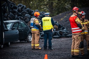 Zdjęcie przedstawiające Policjanta oraz Strażaków na miejscu zdarzenia drogowego.