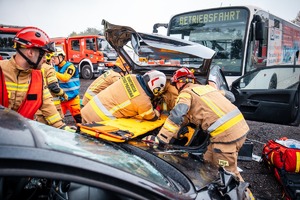Zdjęcie przedstawiające Strażaków oraz uszkodzony samochód osobowy i autobus.