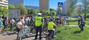 Zdjęcie przedstawiające Policjanta oraz dzieci przystępujące do karty rowerowej.