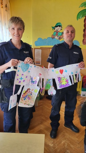 Zdjęcie przedstawiające Policjantów trzymających laurkę.