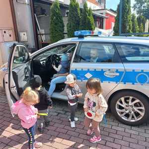 Zdjęcie przedstawiające dzieci oraz Policyjny radiowóz.