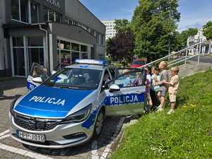 Zdjęcie przedstawiające radiowóz oraz dzieci.