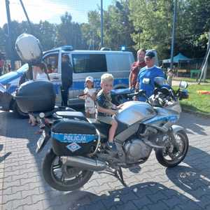 Zdjęcie przedstawiające chłopca na motocyklu Policyjnym.