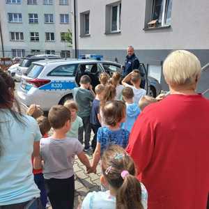 Zdjęcie przedstawiające Policjanta i dzieci oraz uczestników spotkania.