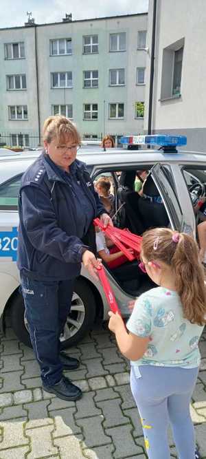 Zdjęcie przedstawiające Policjantkę w trakcie rozdawania odblasków.
