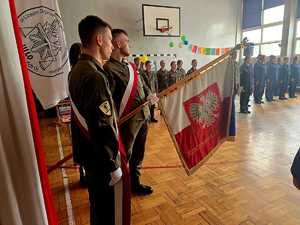 Zdjęcie przedstawiające uczniów klas mundurowych trzymających Sztandar szkoły.