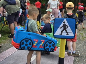 Zdjęcie przedstawiające dzieci bawiące się Mobilnym Miasteczkiem Ruchu Drogowego.