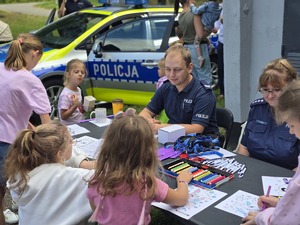 Zdjęcie dzieci, które rysują kolorowankę przy stoisku profilaktycznym.