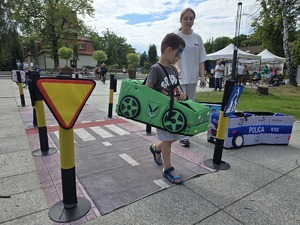 Zdjęcie przedstawiające dzieci bawiące się Mobilnym Miasteczkiem Ruchu Drogowego.