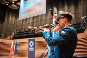 Zdjęcie przedstawiające Policjanta grającego na trąbce.
