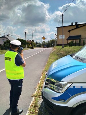 Zdjęcie przedstawiające policjanta ruchu drogowego oraz radiowóz.