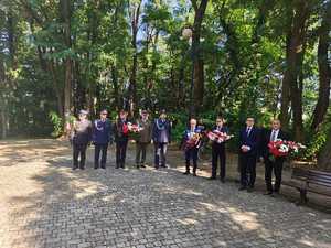 Zdjęcie zebranych na uroczystościach i składających kwiaty.