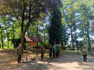 Zdjęcie zebranych na uroczystościach i składających kwiaty.