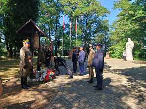 Zdjęcie zebranych na uroczystościach i składających kwiaty.