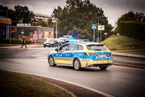 Zdjęcie radiowozu oraz pojazdów uczestniczących w korowodzie.
