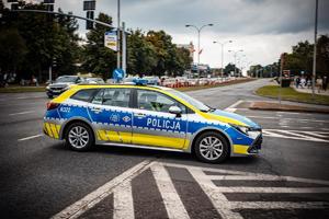 Zdjęcie radiowozu oraz pojazdów uczestniczących w korowodzie.