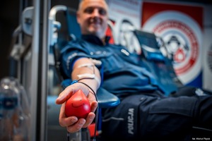 Zdjęcie przedstawiające policjanta w trakcie pobrania krwi.