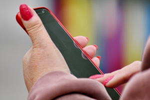 Zdjęcie dłoni trzymającej telefon.