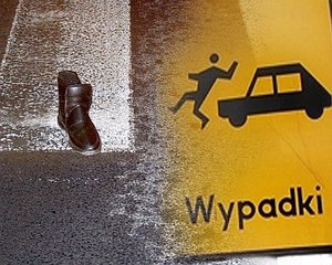 Zdjęcie przedstawiające plakat, na którym widzimy samochód i potrąconego pieszego.