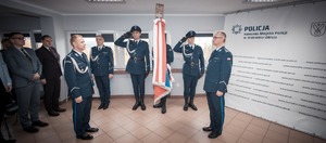 Zdjęcie przedstawiające Panów Komendanta stojących przy sztandarze.