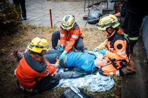 Zdjęcie przedstawiające uczestników biorących udział w wykonywanym zadaniu, przy udzielaniu pierwszej pomocy.