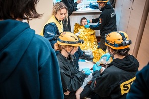 Zdjęcie przedstawiające uczestników biorących udział w wykonywanym zadaniu oraz policjantkę.