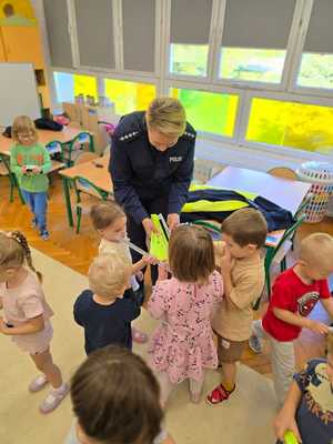 Zdjęcie przedstawiające bawiące się dzieci miasteczkiem ruchu drogowego.