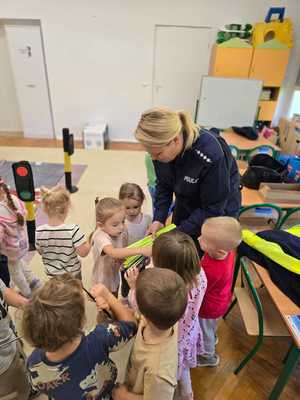 Zdjęcie przedstawiające bawiące się dzieci miasteczkiem ruchu drogowego.