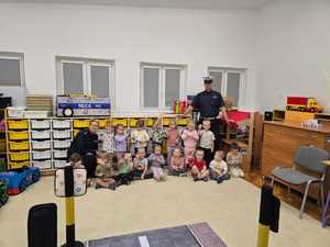 Zdjęcie przedstawiające bawiące się dzieci miasteczkiem ruchu drogowego.