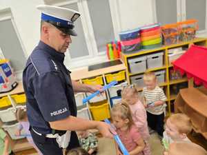 Zdjęcie przedstawiające bawiące się dzieci miasteczkiem ruchu drogowego.