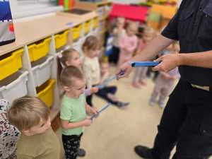 Zdjęcie przedstawiające bawiące się dzieci miasteczkiem ruchu drogowego.