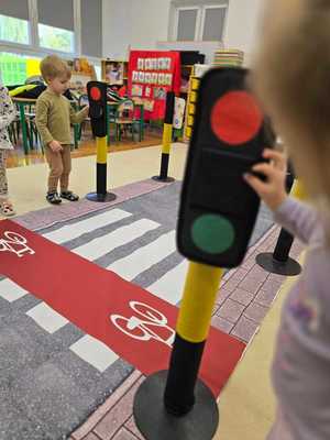 Zdjęcie przedstawiające bawiące się dzieci miasteczkiem ruchu drogowego.