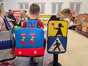 Zdjęcie przedstawiające bawiące się dzieci miasteczkiem ruchu drogowego.