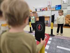 Zdjęcie przedstawiające bawiące się dzieci miasteczkiem ruchu drogowego.