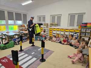 Zdjęcie przedstawiające bawiące się dzieci miasteczkiem ruchu drogowego.