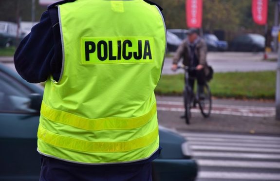 Zdjęcie policjanta w kamizelce z napisem Policja.