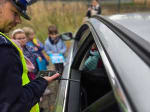 Zdjęcie policjanta oraz dzieci w trakcie kontroli drogowej.
