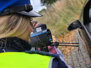 Zdjęcie policjantki oraz dzieci w trakcie kontroli drogowej.