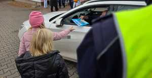 Zdjęcie policjanta oraz dzieci w trakcie kontroli drogowej.