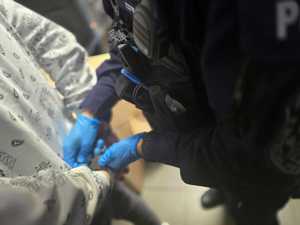 Zdjęcie policjanta zakładającego kajdanki osobie zatrzymanej.