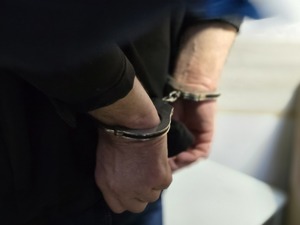 Zdjęcie przedstawiające ręce z założonymi kajdankami.