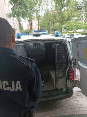 Zdjęcie policjanta oraz mężczyzny zatrzymanej w radiowozie.