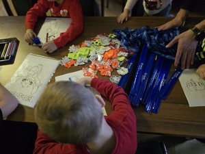 Zdjęcie przedstawiające dzieci, kolorujące przy policyjnym stoisku.