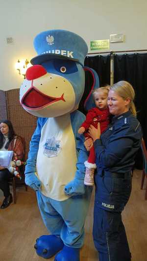 Zdjęcie przedstawiające policjantkę, Sznupka oraz dziecko.