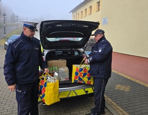 Zdjęcie przedstawiające policjantów niosących prezenty.