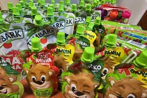 Zdjęcie przedstawiające zebrane rzeczy do przekazania, soczki.