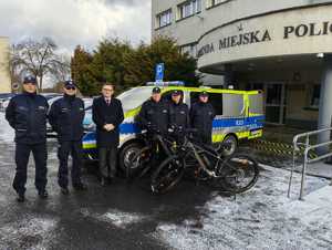 Zdjęcie nowego radiowozu policyjnego, policjantów oraz dwóch rowerów.